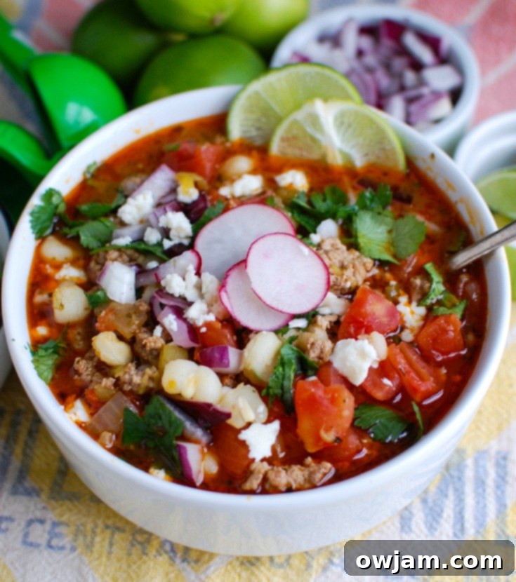 A spoonful of Slow Cooker Pork Pozole, showcasing the hominy and pork pieces.