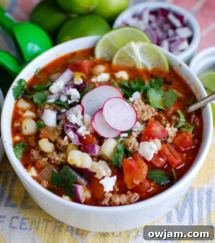 Tender Slow Cooker Pork Pozole 4 Slow Cooker Pork Pozole in a white bowl with a spoon, ready to be enjoyed.