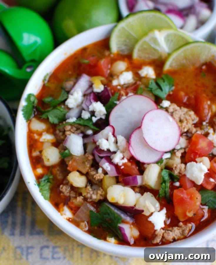 Tender Slow Cooker Pork Pozole 5 Slow Cooker Pork Pozole garnished with lime wedges and cilantro.