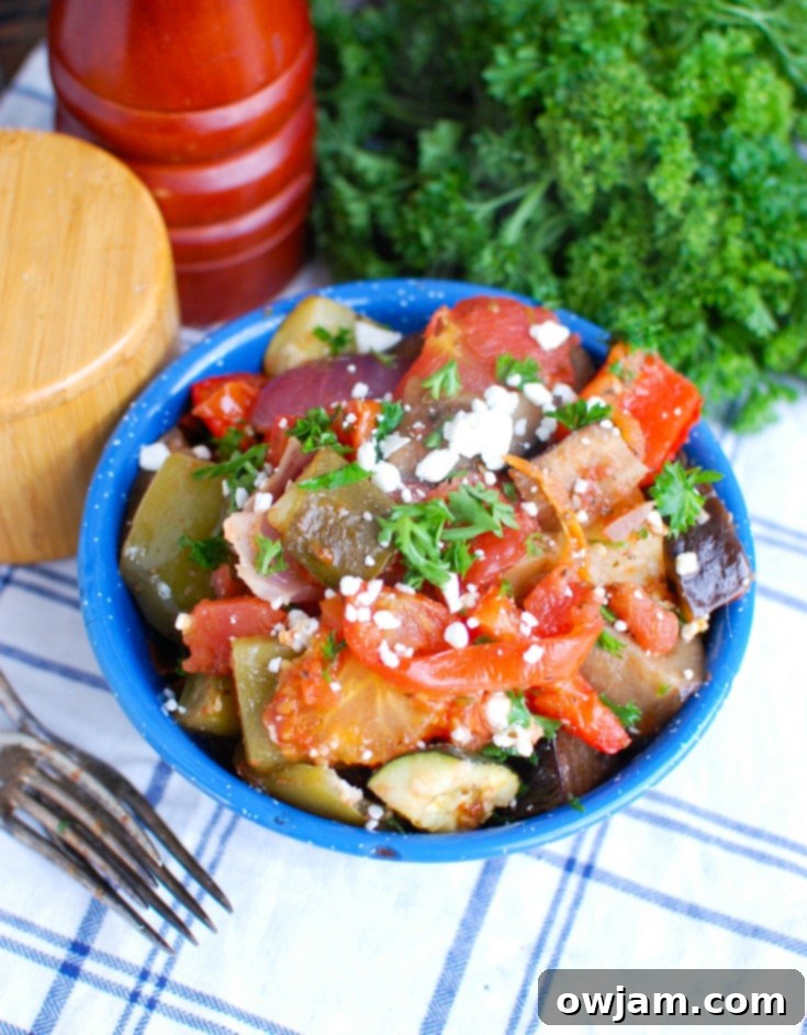 Greek Briami Roasted Vegetables 4 An overhead shot of Greek Roasted Vegetables (Briami) in a rustic baking dish, garnished with fresh herbs.