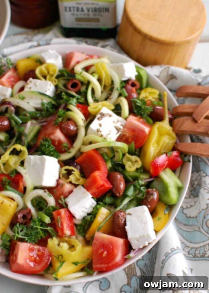 Spiralized Greek Style Salad with wooden tongs