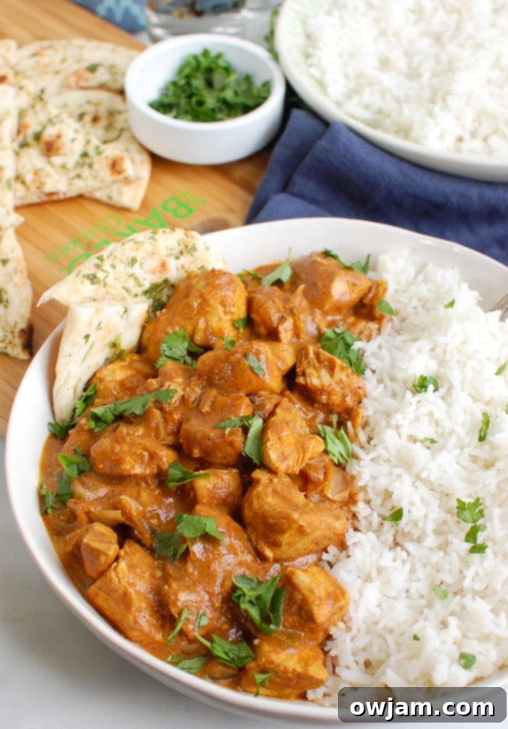 Slow Cooker Butter Chicken in a white bowl with cilantro