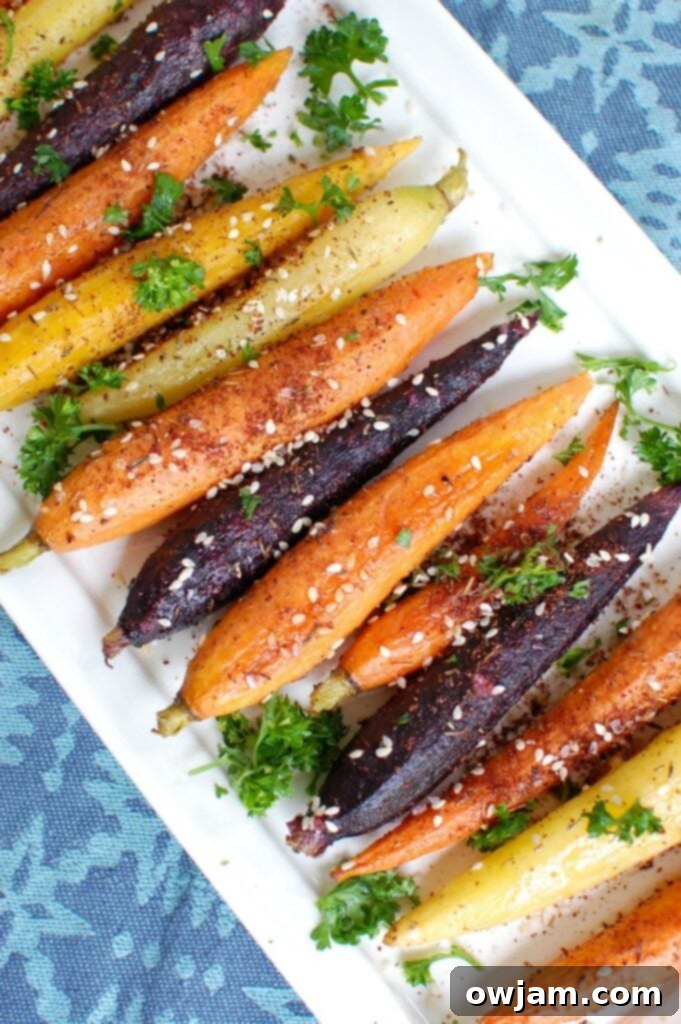Close-up of vibrant Za'atar Roasted Carrots on a platter, showcasing the golden-brown edges and green parsley garnish.