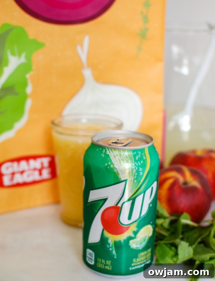 Zesty Peach Sparkle 3 Ingredients laid out for Sparkling Peach Lemonade: fresh peaches, lemonade concentrate, 7UP, and mint.