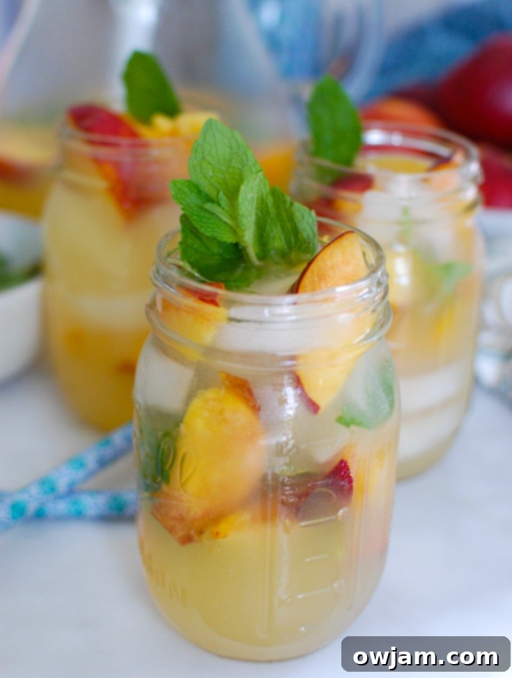 Zesty Peach Sparkle 4 Three glasses of Sparkling Peach Lemonade, garnished beautifully, ready to be served.