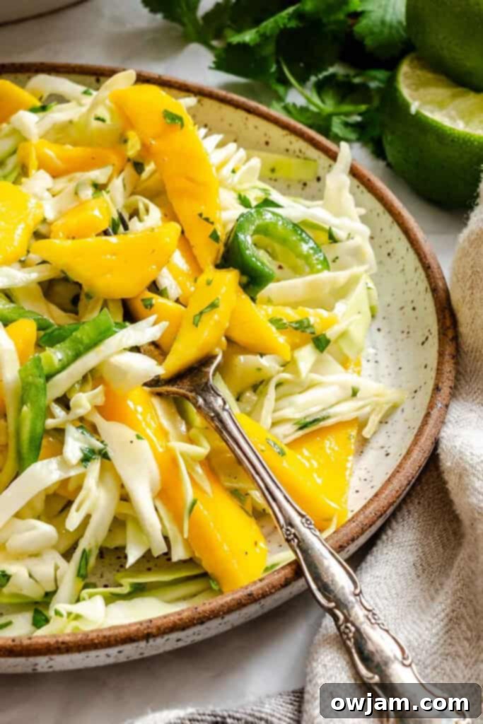Quick Tropical Mango Cabbage Slaw 3 Easy Mango Cabbage Coleslaw with a fork, ready to be enjoyed