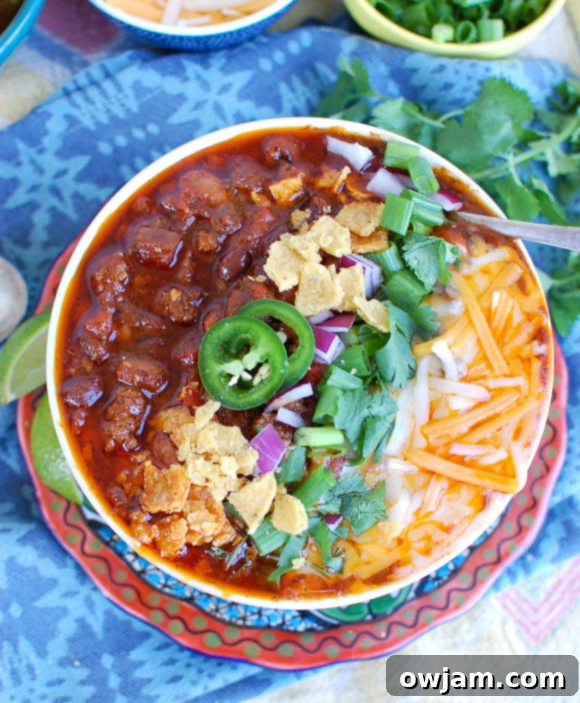 Quick Instant Pot Beef Chili 3 Easy Instant Pot Beef Chili served in a rustic bowl, viewed from above, with various toppings.