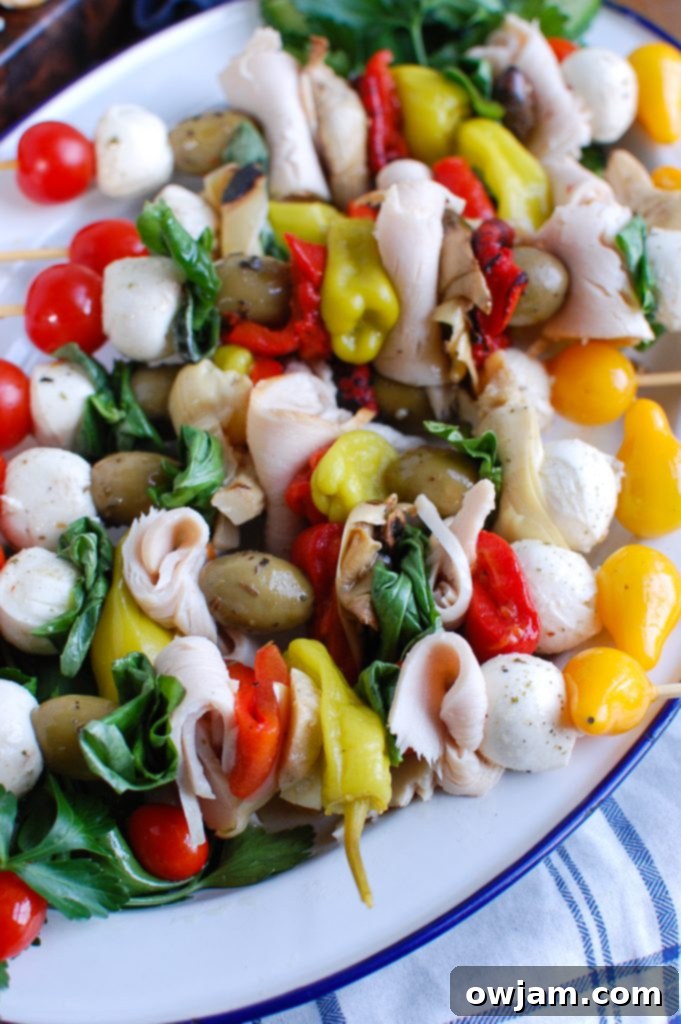 Close-up of Mediterranean Antipasto Skewers featuring Kretschmar Off The Bone turkey breasts, olives, mozzarella, and vegetables on a white serving plate.