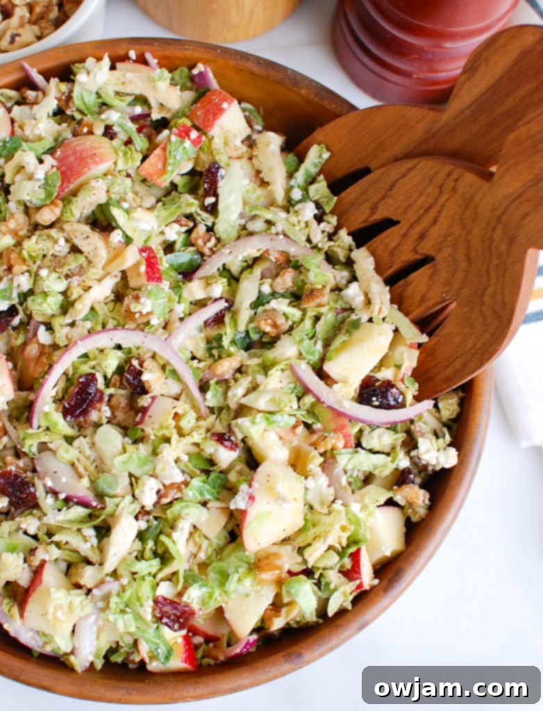 Tangy Goat Cheese, Crisp Apple & Shaved Brussels Sprout Salad 4 Brussels Sprout Apple Goat Cheese Salad with Wooden Tongs ready to serve