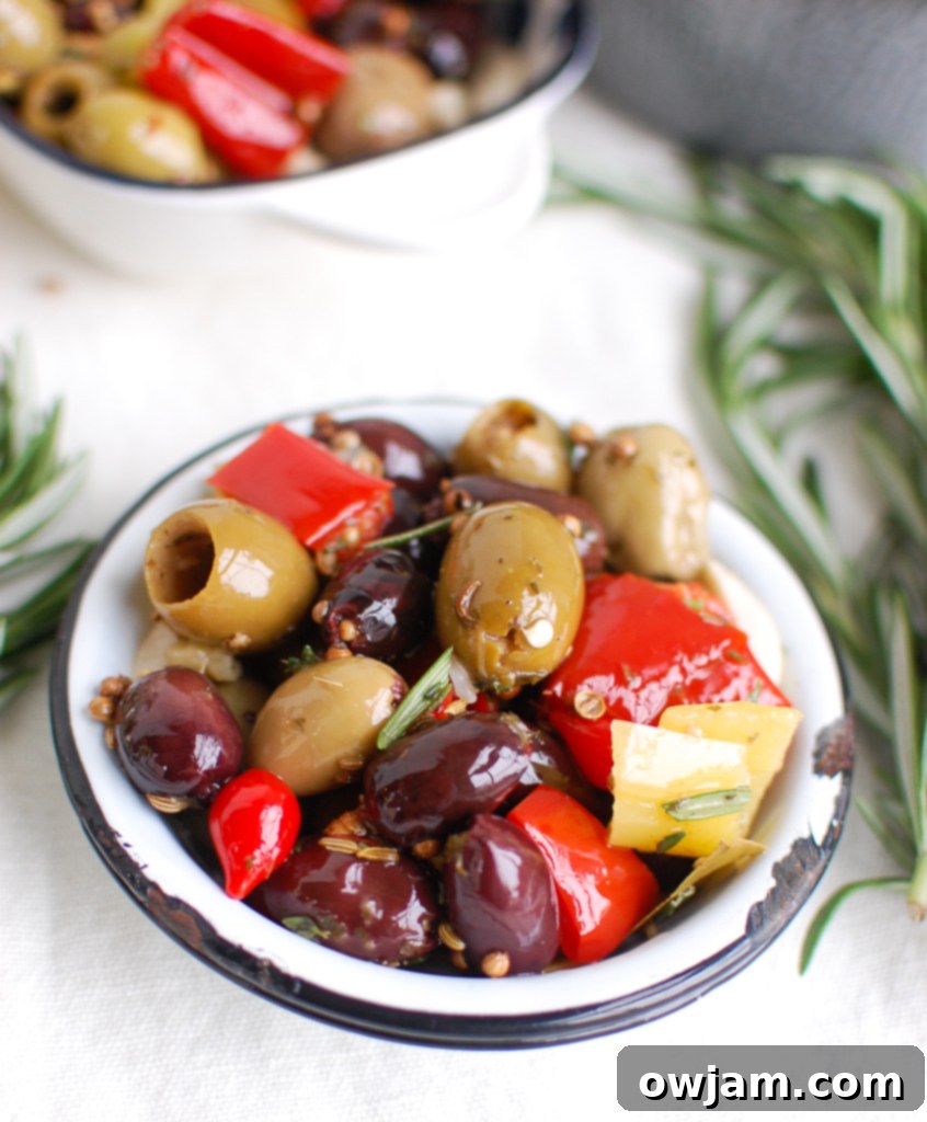 Lemon Marinated Olives in a stylish bowl, with fresh lemon slices and rosemary as garnish