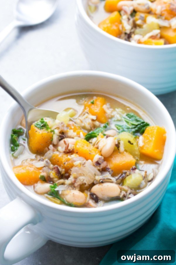 Slow Cooker Wild Rice Vegetable Soup - A steaming bowl of creamy wild rice and vegetable soup, garnished with fresh parsley.