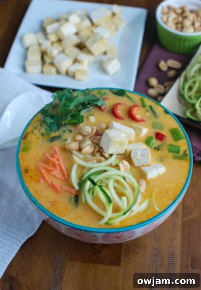 Thai Coconut Zoodle Soup - A vibrant bowl of Thai Coconut Zoodle Soup with spiralized zucchini noodles, herbs, and a rich coconut broth.