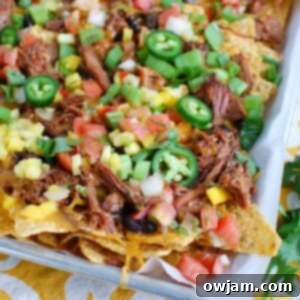 Beef Nachos with a variety of colorful toppings, perfect for game day or Cinco de Mayo.