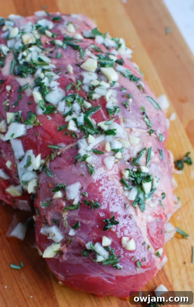 Melt in Your Mouth Roast Beef 3 Rosemary and Garlic Roast Beef with fresh garlic and rosemary ready for preparation