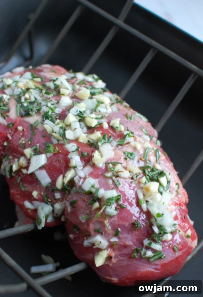Melt in Your Mouth Roast Beef 4 Rosemary and Garlic Roast Beef in a roasting pan, perfectly seasoned and ready for the oven.