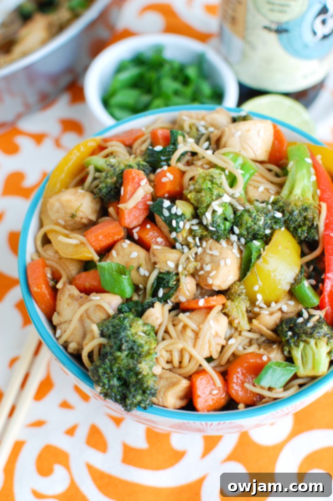 Easy Chicken Ramen Noodle Stir Fry in a bowl, garnished with green onions and sesame seeds