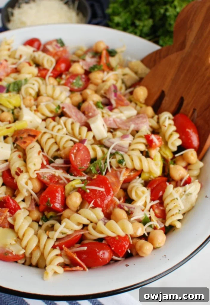 Side view of Italian Pasta Salad in a white serving bowl, showcasing layers of ingredients.