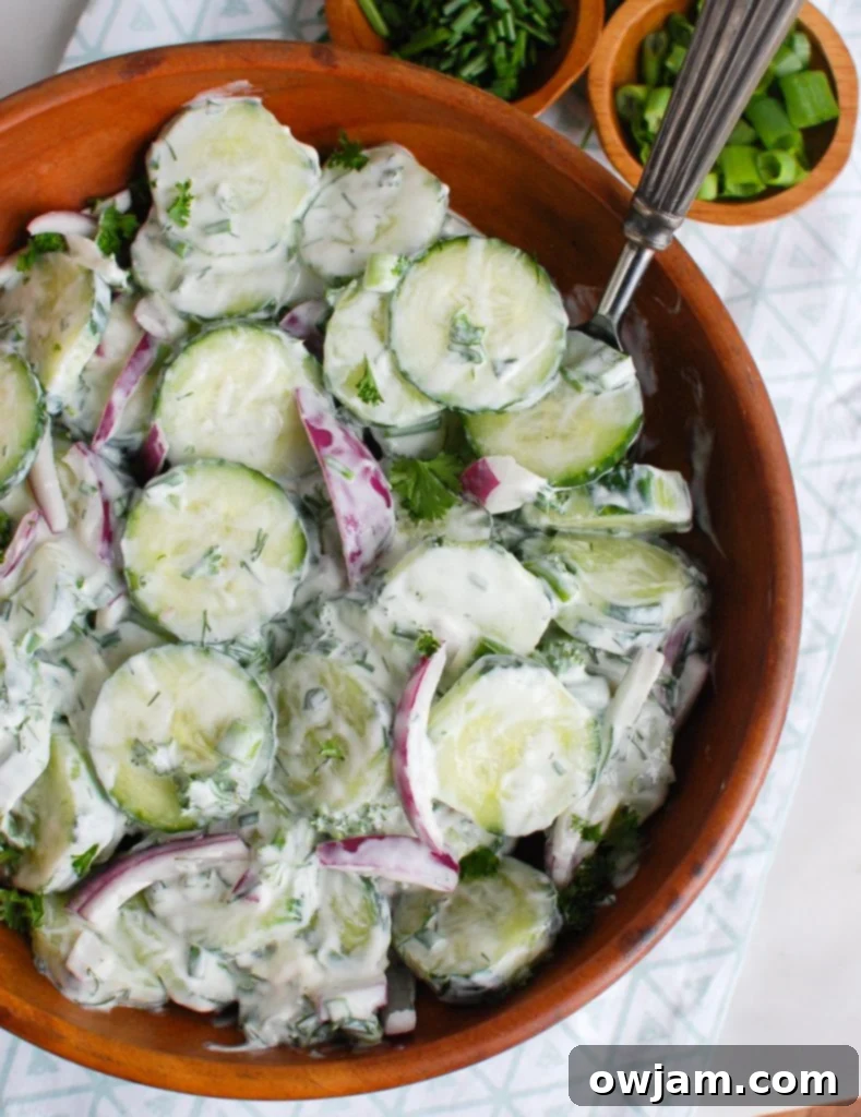 Velvety Cool Cucumber Salad 3 Close-up of creamy cucumber salad in a white bowl with a spoon