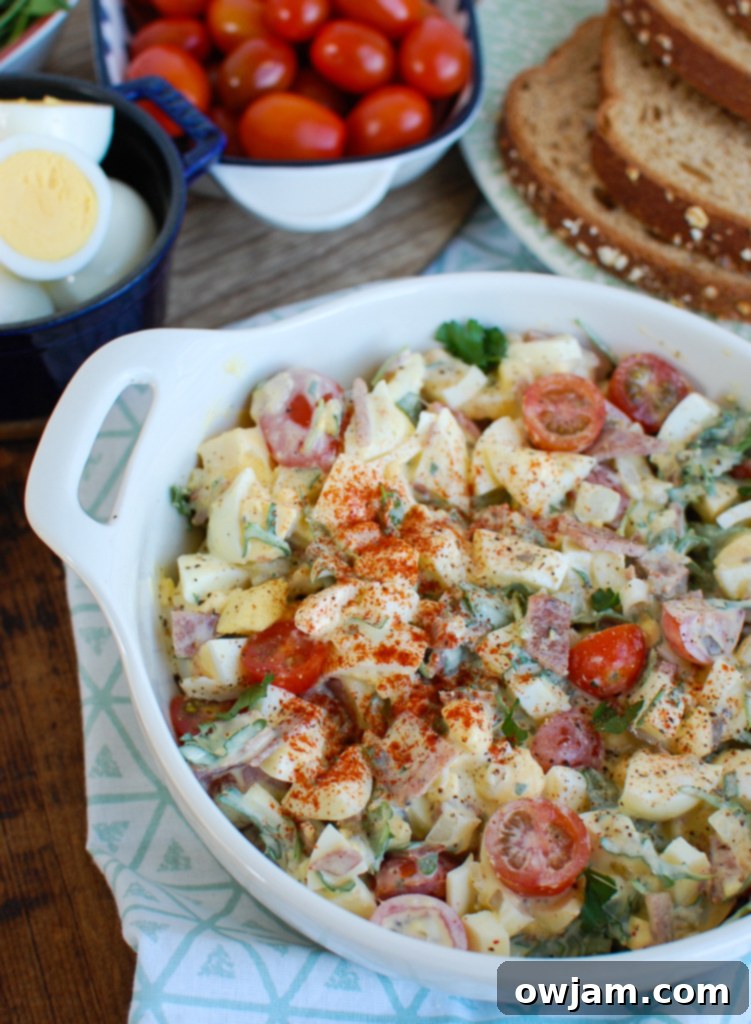 Bacon Egg Salad in a bowl with a serving spoon, ready to be enjoyed.