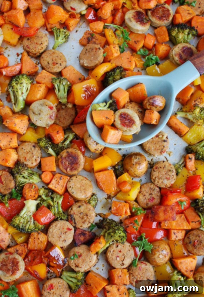 Sheet Pan Chicken Sausage and Vegetables with a serving spoon