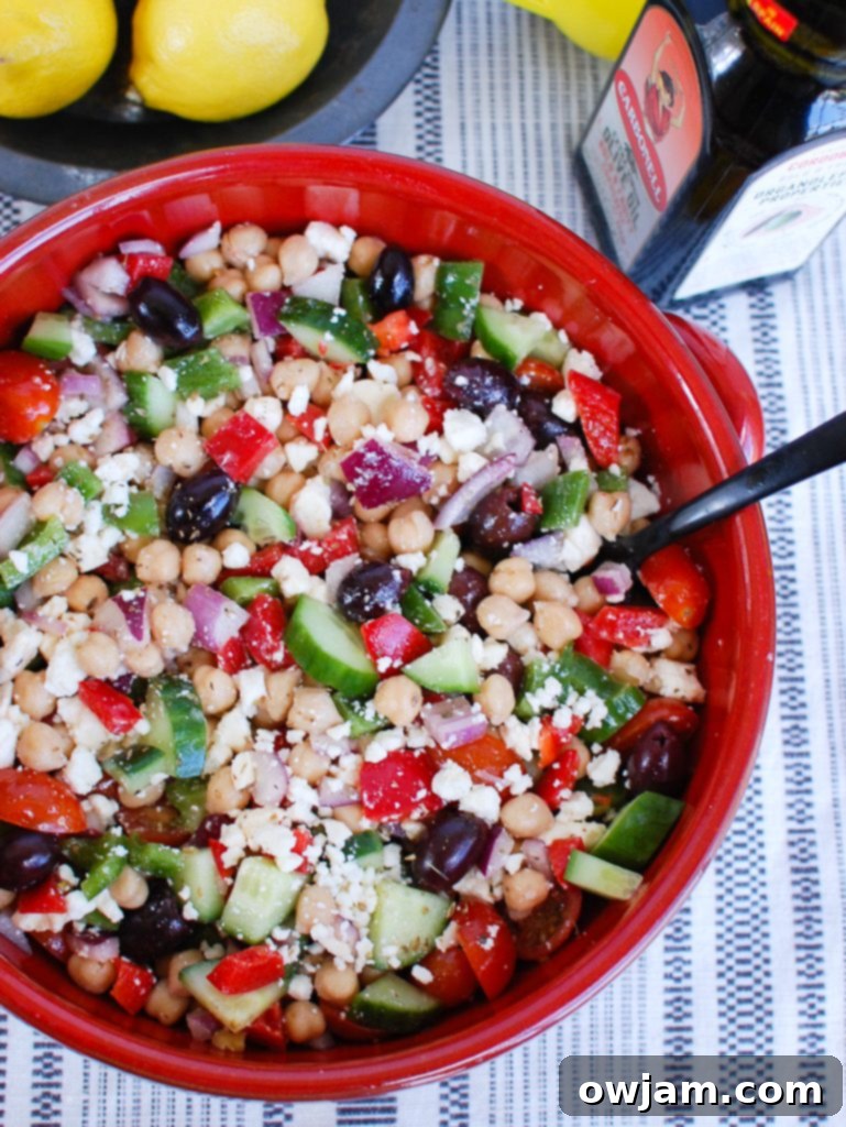 Greek Chickpea Salad ready to be served, with a spoon for enjoyment.
