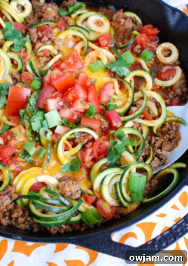 Mexican Zucchini Recipe in a black skillet, showcasing a colorful and healthy one-pan meal with seasoned ground beef and tender zucchini noodles.