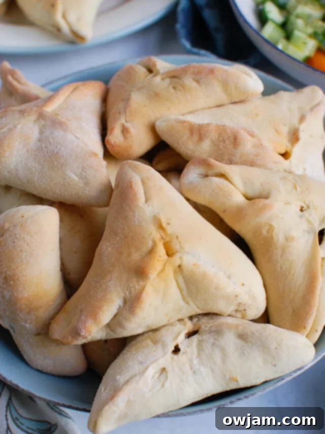 Classic Lebanese Meat Pies (Sfeeha) arranged beautifully in a blue bowl, ready to be served, showcasing their golden-brown crust and inviting appearance.