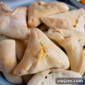 A large bowl filled with freshly baked Lebanese Meat Pies, also known as Sfeeha or Fatayer, showcasing their appealing golden-brown crust.