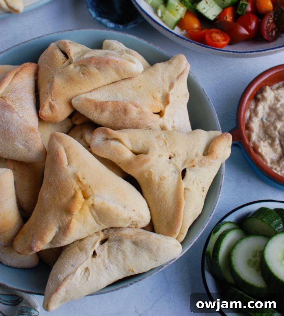 A vibrant display of Lebanese Meat Pies (Sfeeha) served with fresh cucumber slices, highlighting their versatility and delicious pairing with crisp, cool sides.