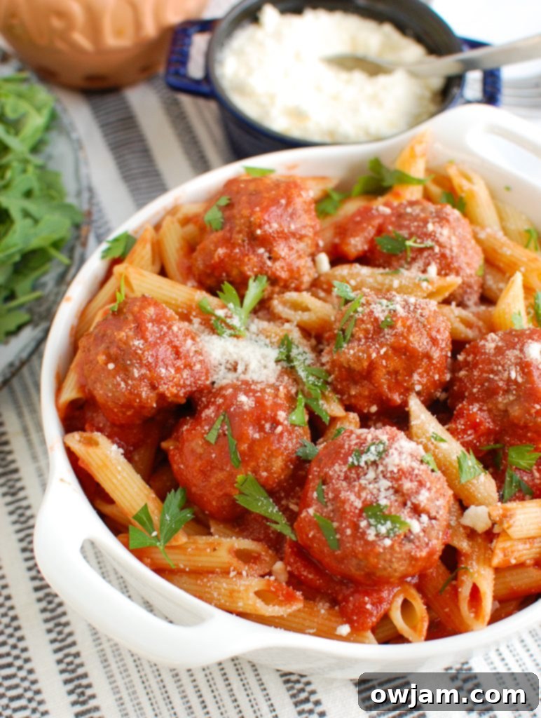 Succulent Pork Meatballs 2 Pork Meatballs in a white bowl with a rich red tomato sauce