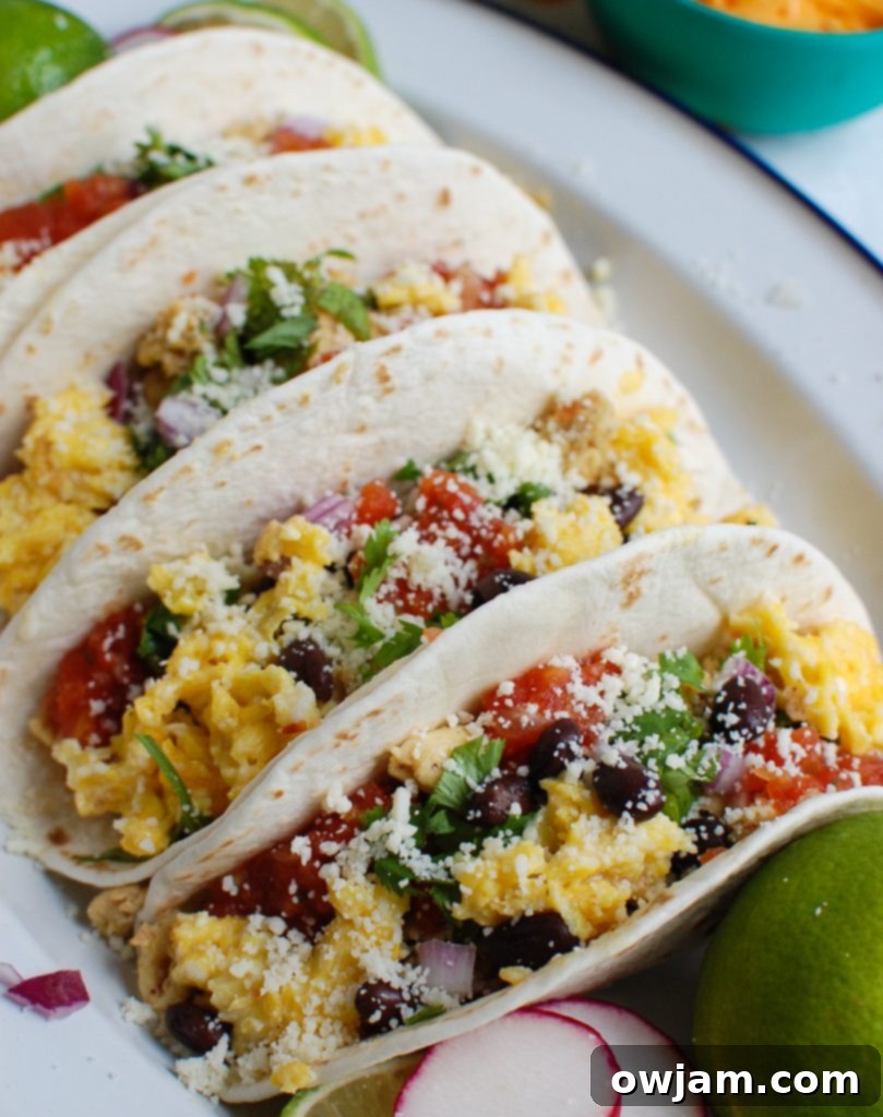 Southwestern Sunrise Tacos 4 Southwest Breakfast Egg Tacos served with a side of fresh salsa, highlighting the vibrant colors of the toppings.