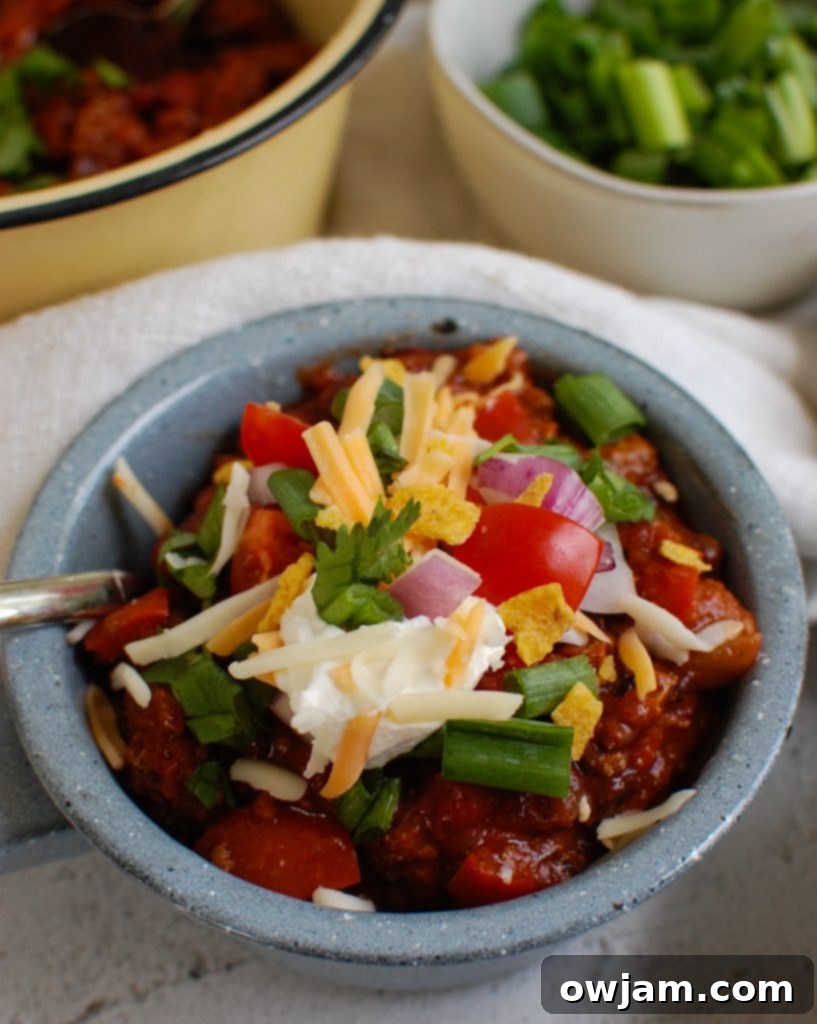 Rich & Robust Beef Chili 4 Beef Chili Recipe garnished with sour cream in a blue bowl