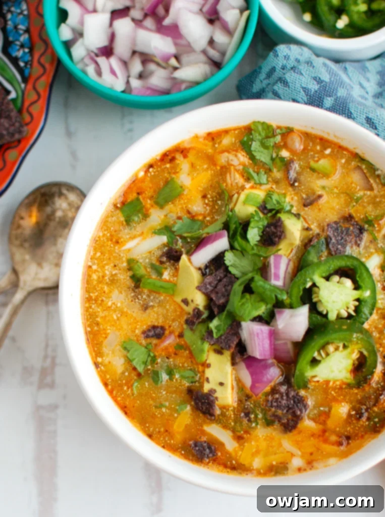 Instant Pot White Chicken Chili with spoon and a bowl of garnishes