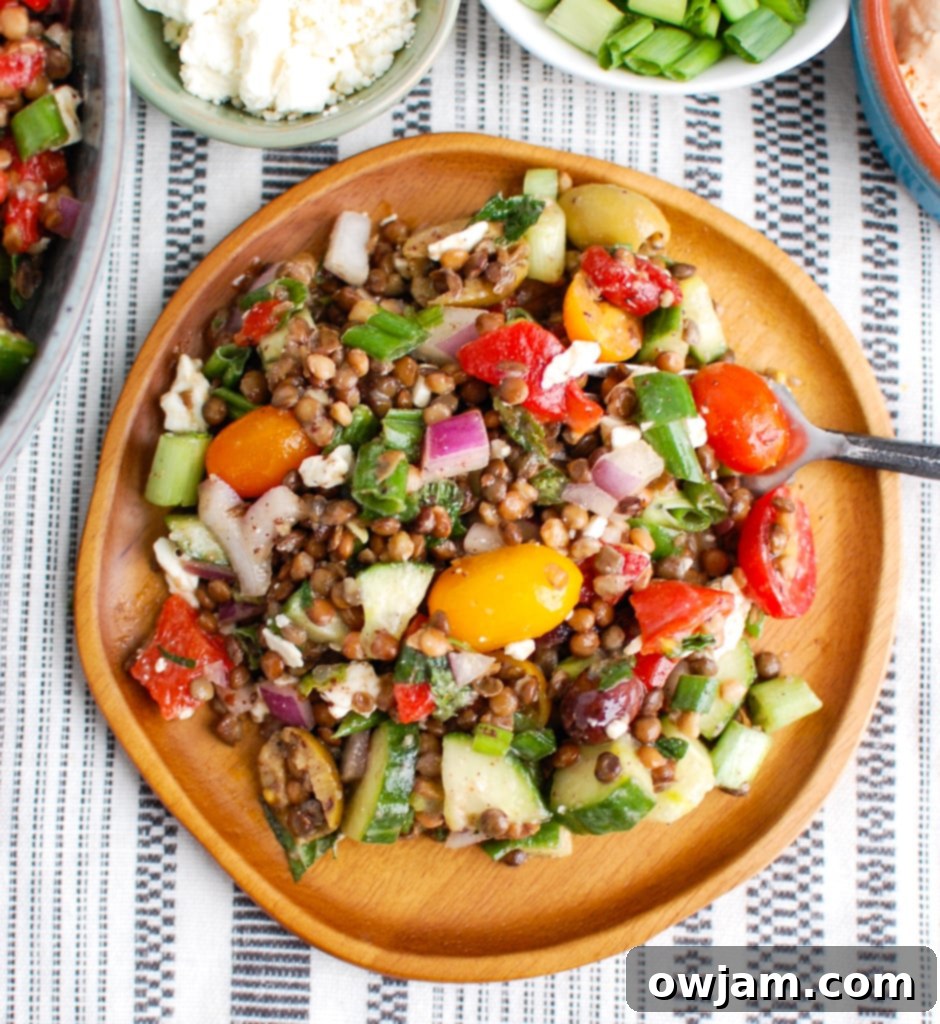Vibrant Mediterranean Lentil Salad 3 Mediterranean Lentil Salad served on a rustic wooden plate with a fork, highlighting fresh textures and colors.