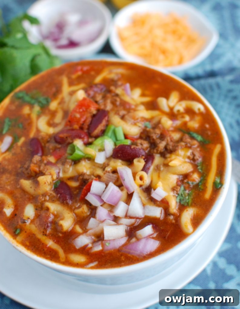 Instant Pot Chili Mac 2 A steaming bowl of Instant Pot Chili Mac, garnished with fresh cilantro and a dollop of sour cream, ready to be enjoyed.