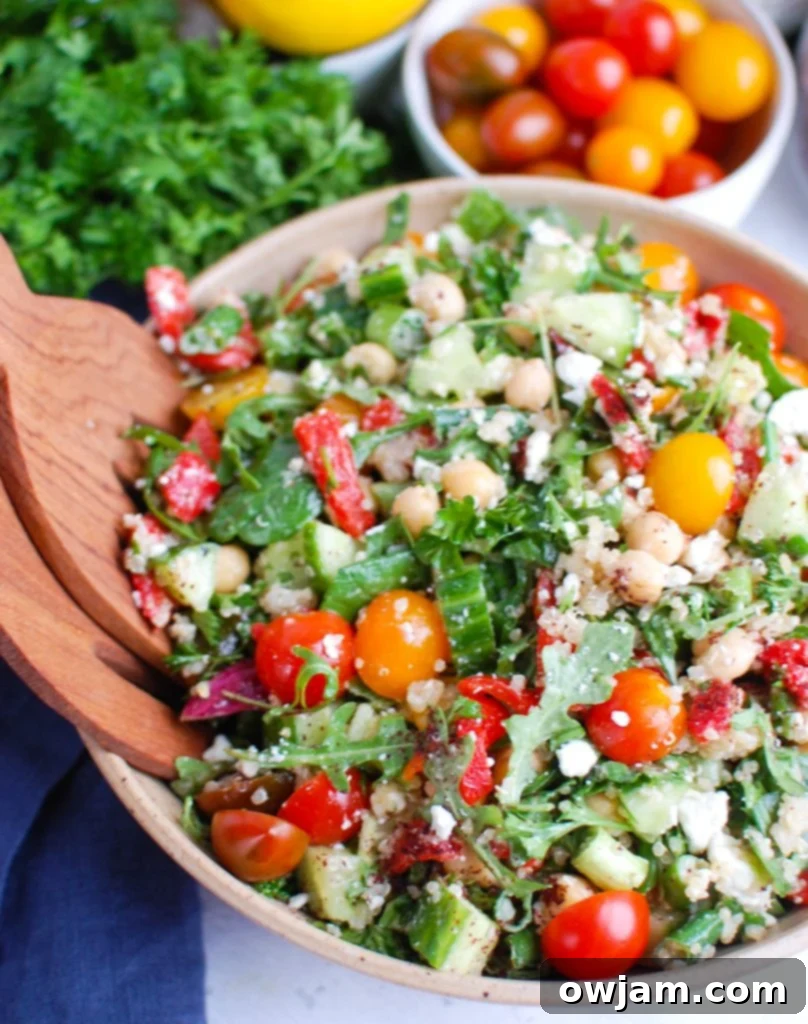 Mediterranean Quinoa Power Bowl 5 Mediterranean Quinoa Salad with wooden serving utensils in a large bowl