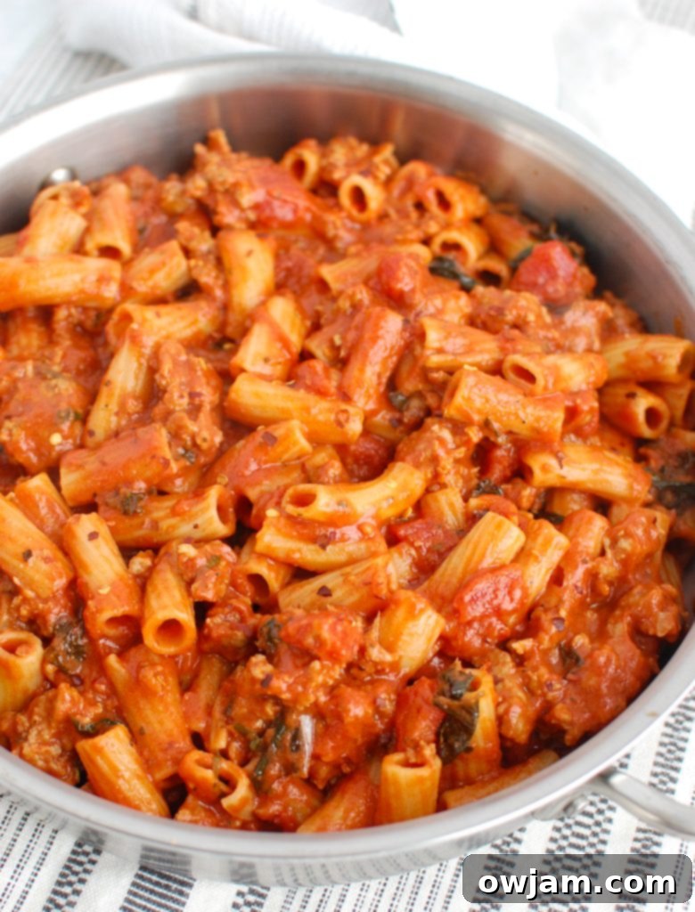 Zesty Sausage Pasta Supper 3 Italian Sausage Pasta simmering in a large pot, showing the rich tomato sauce and crumbled sausage