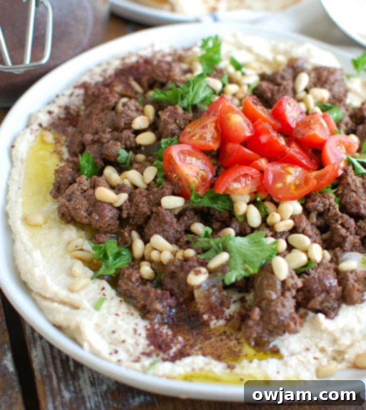 Hummus topped with warmly spiced ground beef and toasted pine nuts