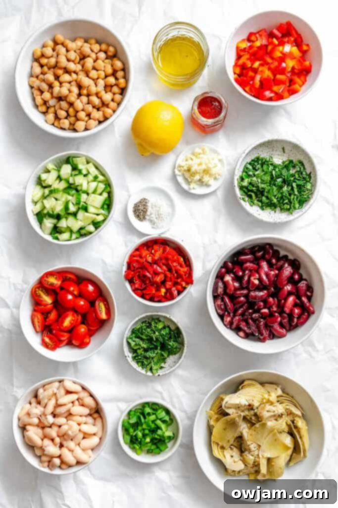 Close-up of fresh, colorful ingredients for Mediterranean Three Bean Salad, including various beans, chopped vegetables, and herbs, ready for mixing.
