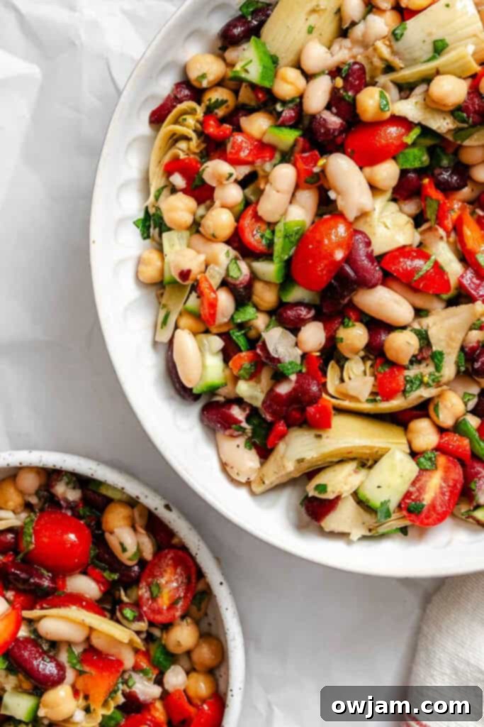 Large white bowl filled to the brim with vibrant Mediterranean Three Bean Salad, ready to be enjoyed as a meal or side.