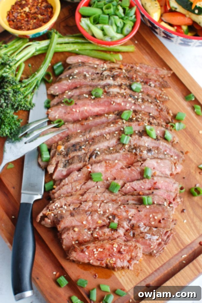Perfectly grilled Asian Marinated Flank Steak served on a cutting board, ready for slicing