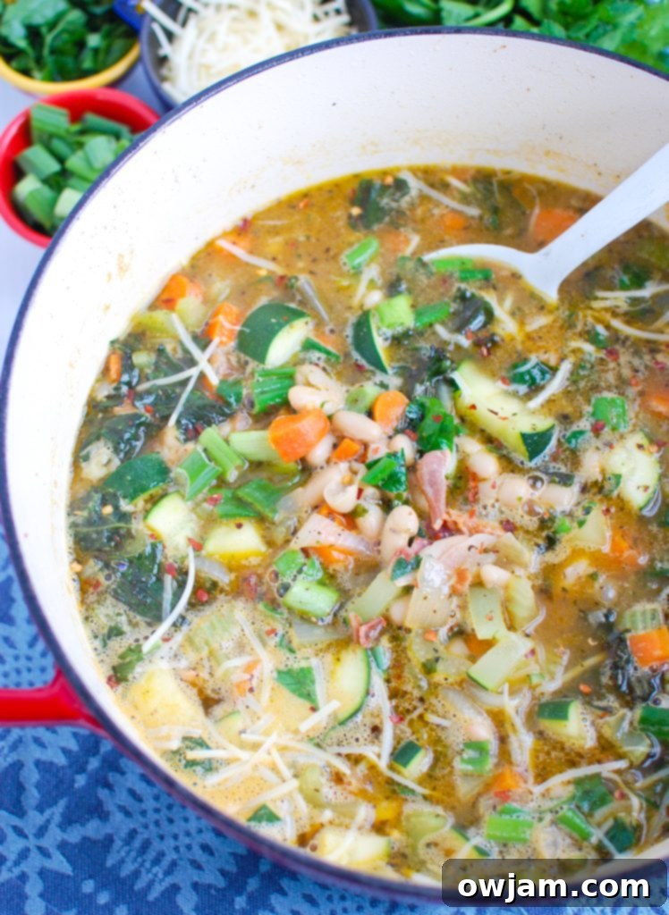 Rustic Tuscan Bean Soup 3 Tuscan Bean Soup simmering in a large pot on the stovetop, showcasing the vibrant vegetables and beans.