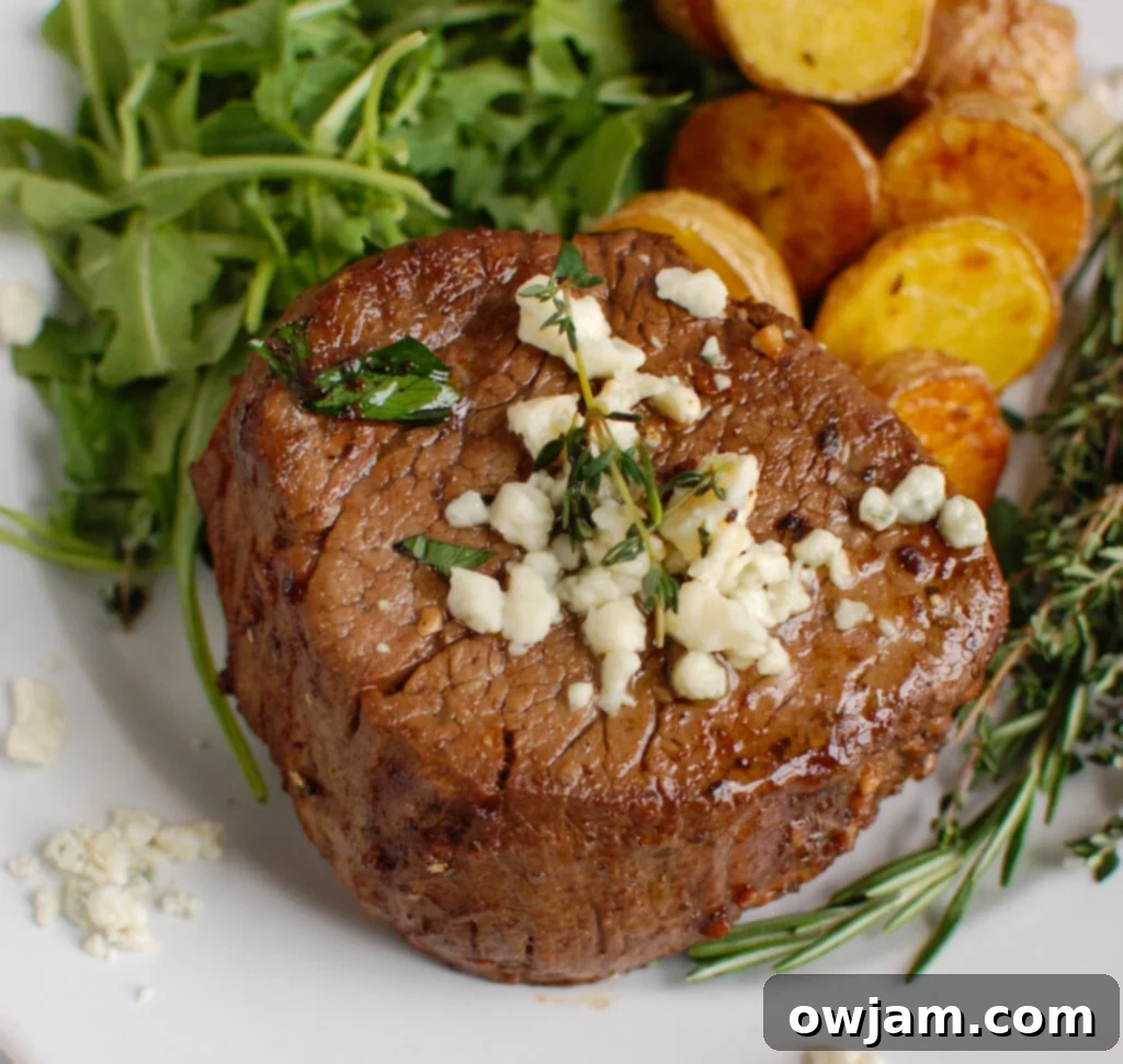 Decadent Tenderloin with Tangy Blue Cheese 2 Perfectly cooked Beef Tenderloin Steaks with Creamy Blue Cheese Sauce, garnished with fresh rosemary.