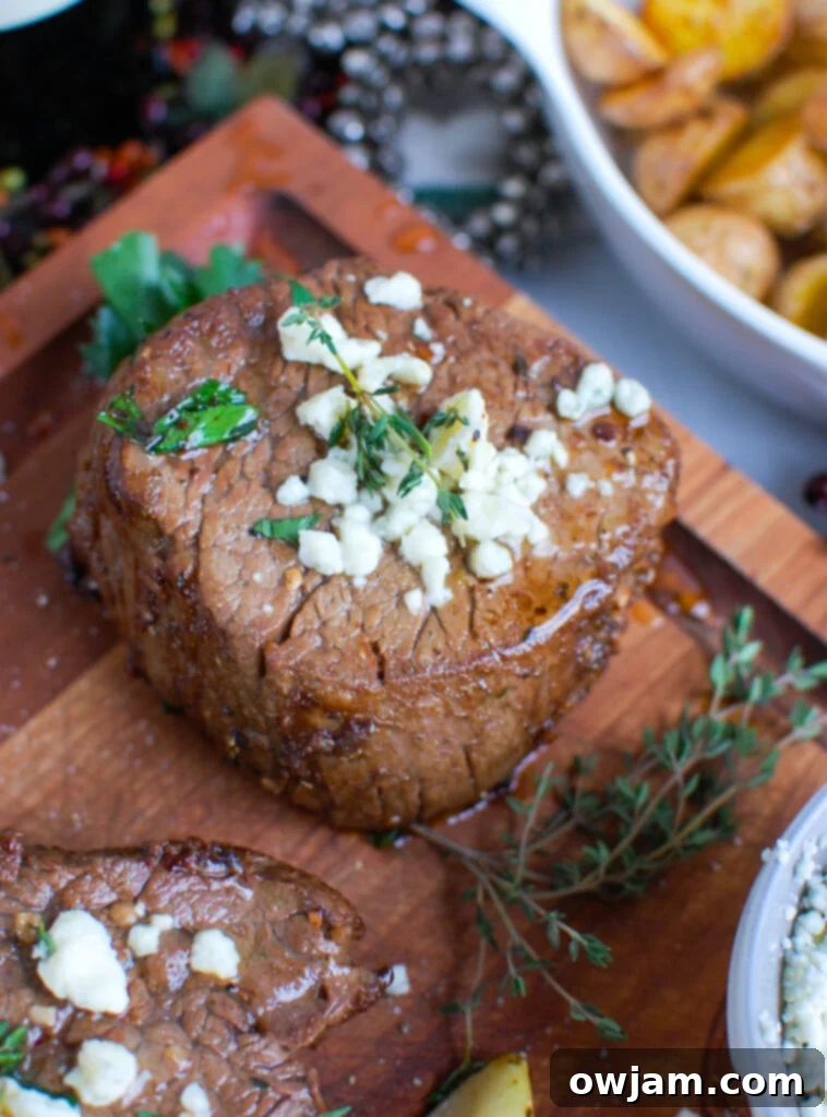Decadent Tenderloin with Tangy Blue Cheese 4 Cooked Beef Tenderloin Steaks resting on a cutting board, ready to be sliced and served with the creamy blue cheese sauce.