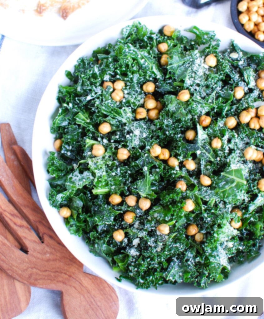 Elevated Kale Caesar 5 Kale Caesar Salad topped with generous amounts of freshly grated Parmesan cheese, glistening with dressing.