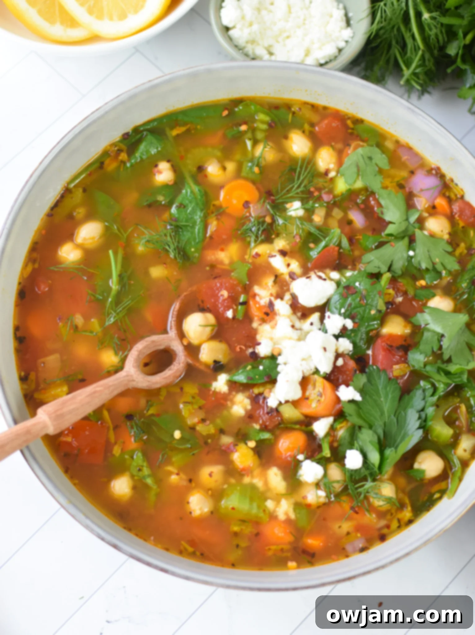 Garbanzo Soup Recipe with a spoon and feta cheese.