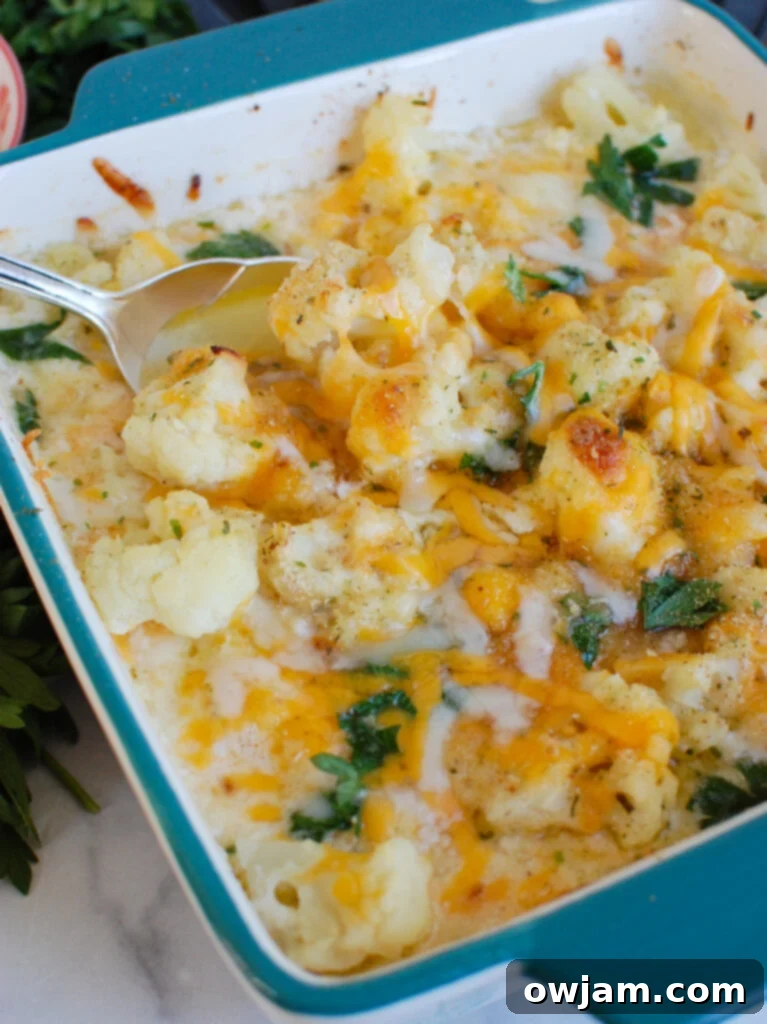 Cauliflower Cheese 4 Cheesy Cauliflower with a spoon, ready to serve