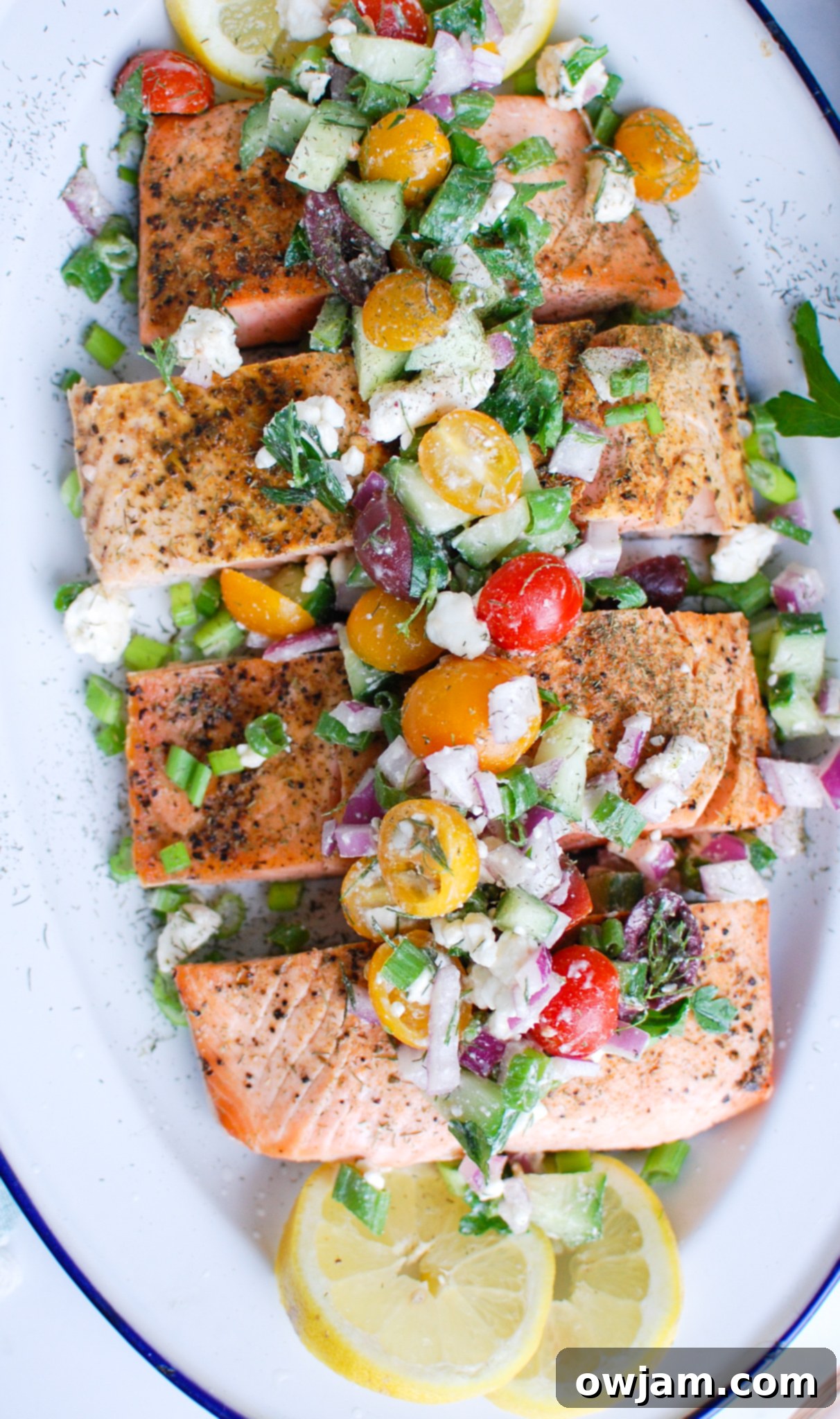 Your New Favorite Mediterranean Baked Salmon 5 a platter with fish and fresh vegetables on top.