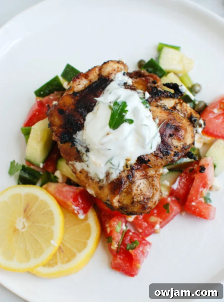 Zesty Greek Chicken with Cool Tzatziki 2 Greek Marinated Chicken with Tzatziki with yogurt on top, garnished with fresh herbs