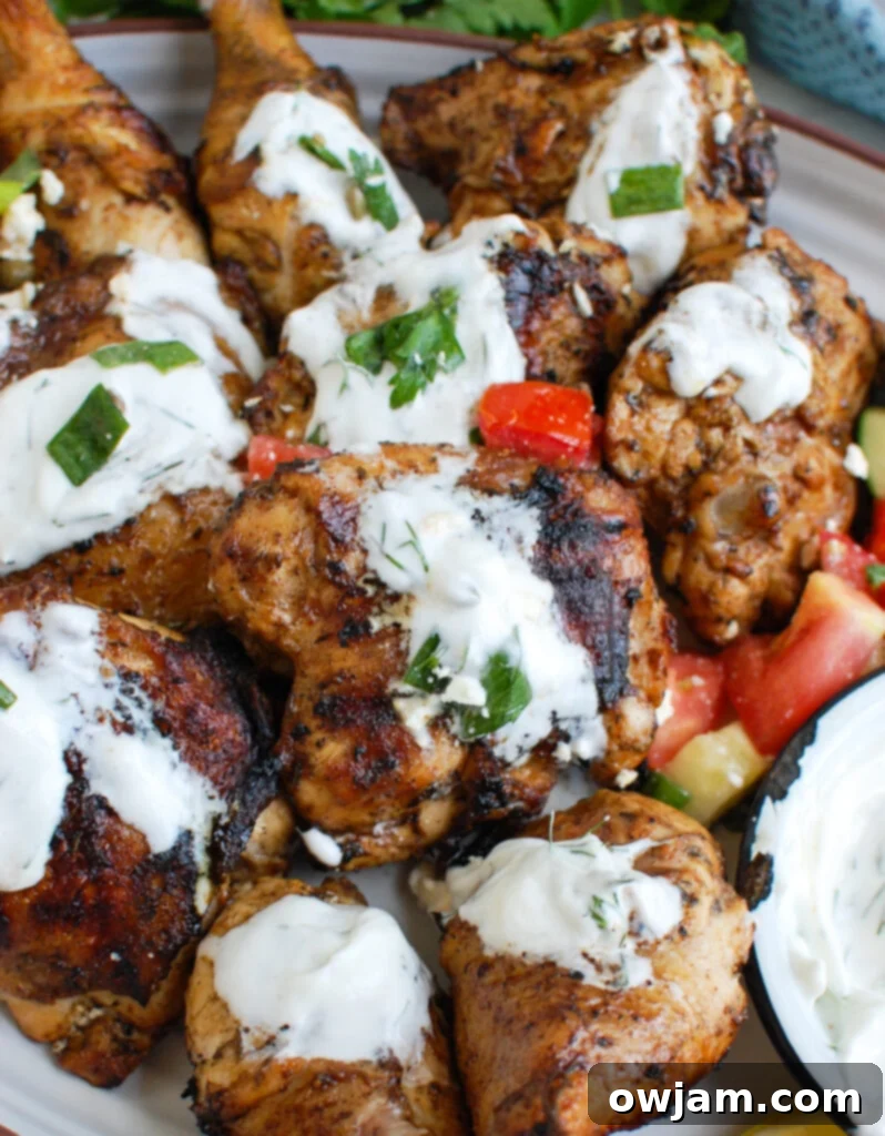 Zesty Greek Chicken with Cool Tzatziki 3 Mediterranean Grilled Chicken with Dill Greek Yogurt Sauce on platter, garnished with fresh herbs